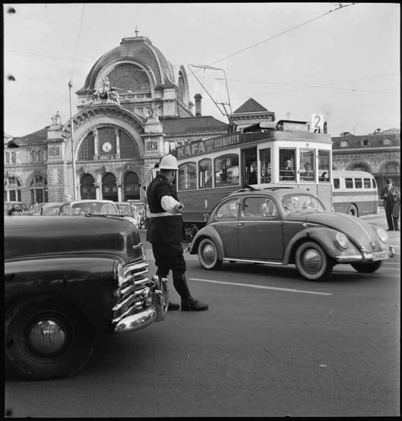 Zwischen Fussgänger und Autos ein Tram beim Bahnhof um 1960.