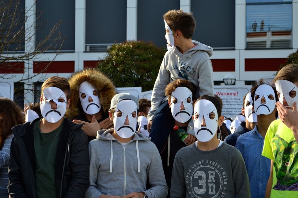 Die Maske soll dem Unmut der Lernenden Ausdruck verleihen.