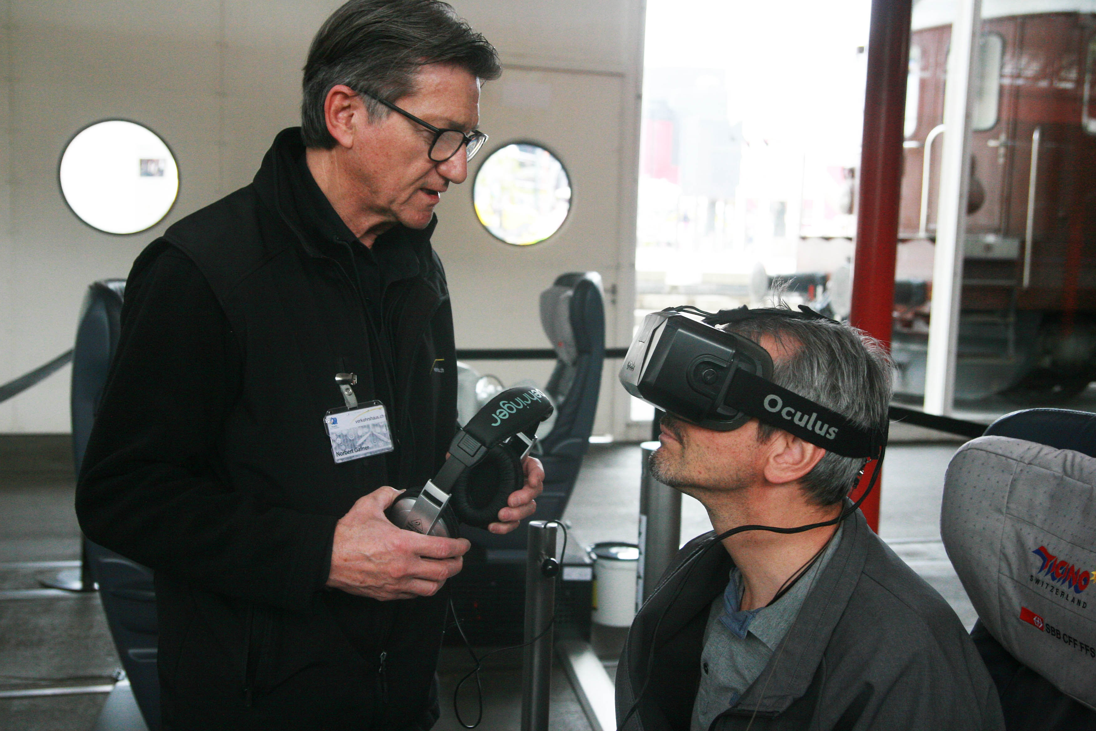 Marc Zihlmann (sitzend) lässt sich die 3D-Brille von einem Verkehrshaus-Mitarbeiter erklären.