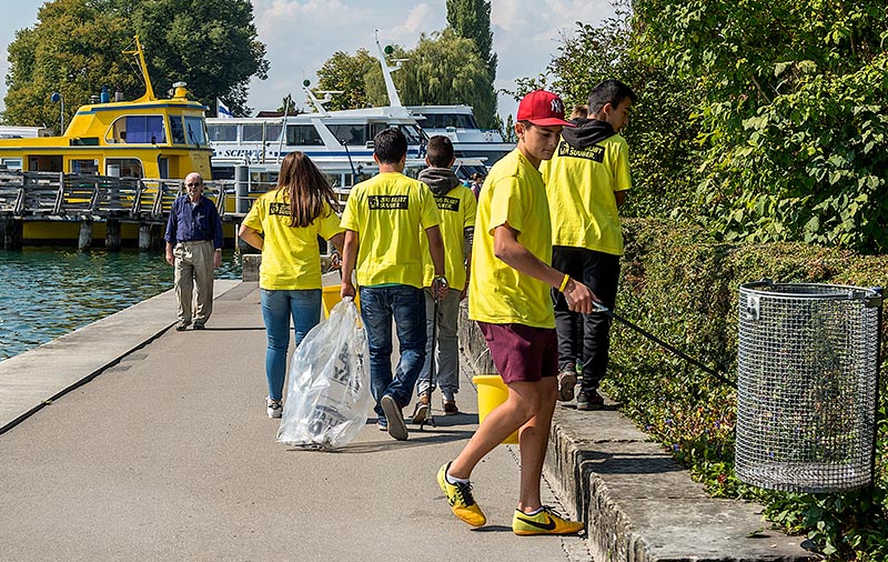 Clean Up Day Zug, Jugendliche sammeln in der ganzen Stadt Litteringabfaelle. Urs Raschle hilft ihnen dabei beim Fundbuero fuer gefundenen Abfall. Hier ein Team beim Sammeln am See