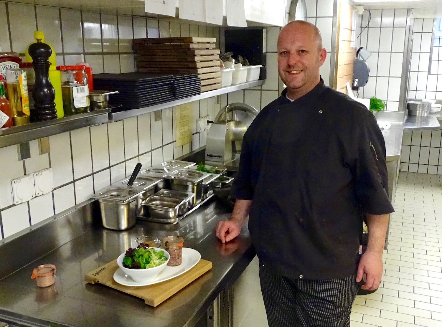 Küchenchef Daniel Marti präsentiert einen Salat mit einer Sulzterrine, die Würfel vom Kalbskopf und -zunge enthält.