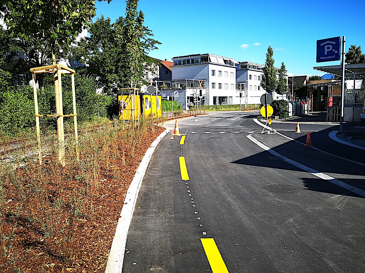 Die nach hinten erweiterte Migros in Cham im Neudorfcenter führt auch zu Veränderungen auf der Neudorfstrasse: Die oberiridischen Längsparkplätze sind nicht mehr da. Links daneben ist das Papieri-Bähnli-Gleis zu sehen, das zu einer Velo- und Fussgängerachse umgebaut wird.