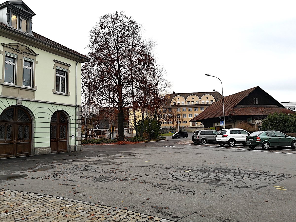 Unbestritten: Dem Chamer Rigiplatz (links das alte Feuerwehrdepot, hinten das Schulhaus Kirchbühl) fehlt die gestalterische Mitte. Doch für das an diesem Standort geplante Verwaltungsgebäude hat die Gemeinde derzeit kein Geld übrig.