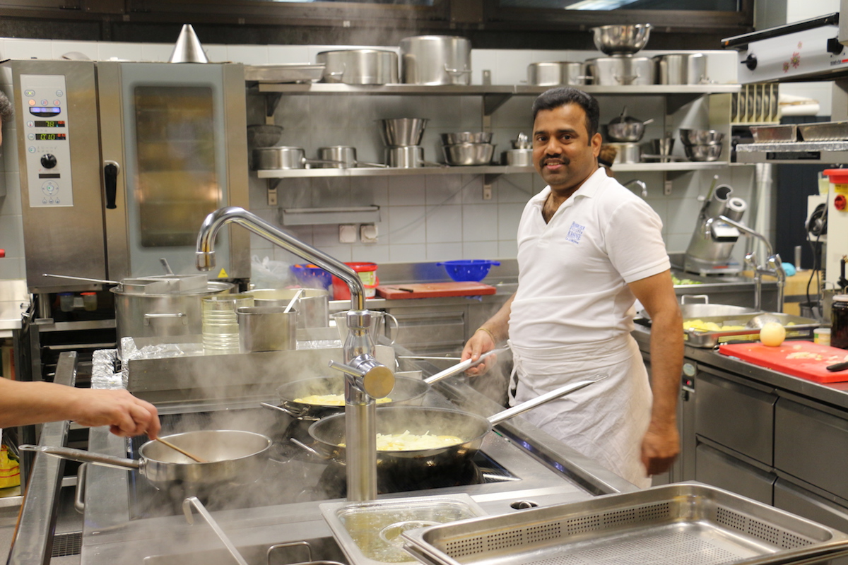 Lingam Yathurai steht in der Küche und bereitet das Mittagessen vor.