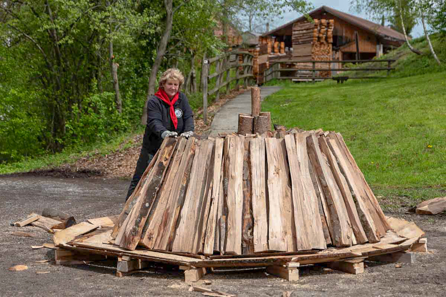 Doris Wicki stellt mit dem Verein Kulturfläck Beromünstereinen Holzkohlemeiler.